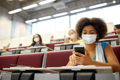 Socially distanced masked college students in classroom during COVID-19 pandemic